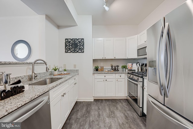 kitchen featuring stainless steel appliances, light stone countertops, sink, and white cabinets