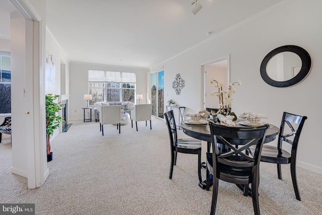 dining room featuring crown molding and light carpet