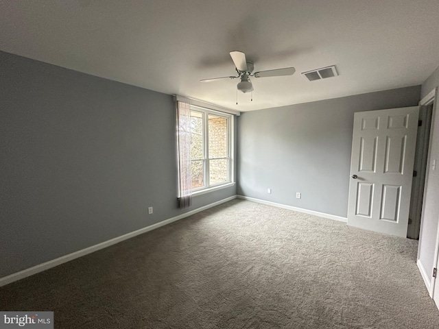 unfurnished room with ceiling fan and carpet