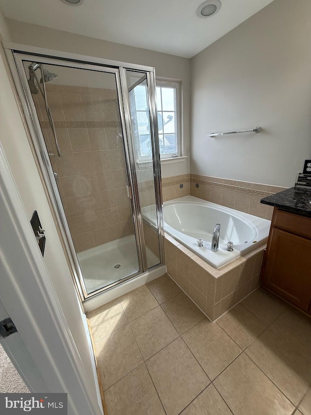 bathroom with plus walk in shower, tile patterned flooring, and vanity