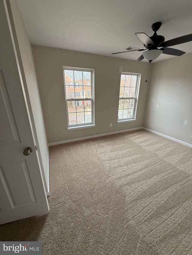 unfurnished room with light colored carpet and ceiling fan