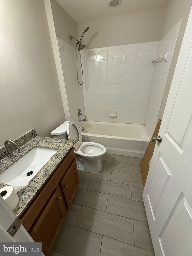 full bathroom featuring toilet, vanity, and tiled shower / bath combo