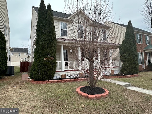 view of front of property featuring a front yard, central AC, and a porch