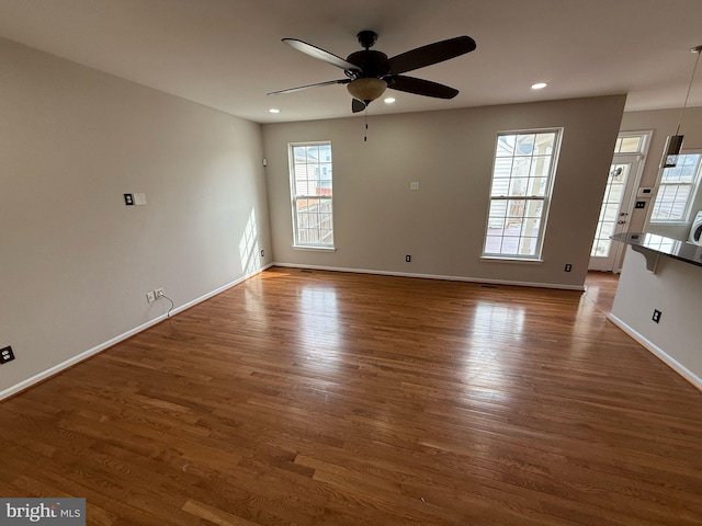 empty room with dark hardwood / wood-style floors and ceiling fan