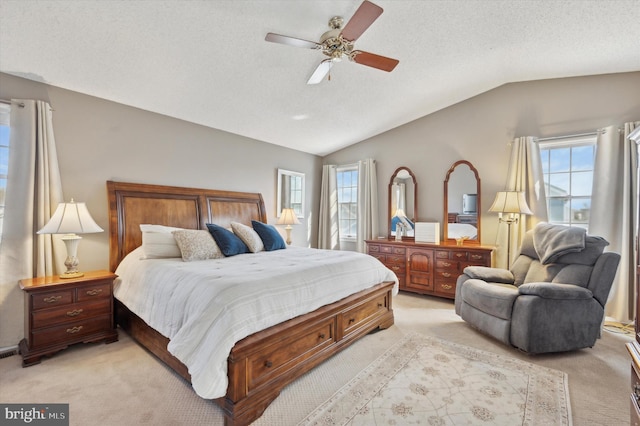 bedroom featuring lofted ceiling, light carpet, a textured ceiling, and multiple windows