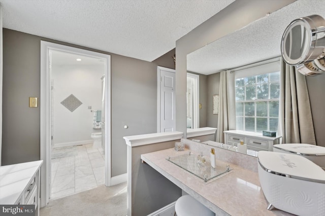 bathroom featuring baseboards, toilet, marble finish floor, a textured ceiling, and vanity