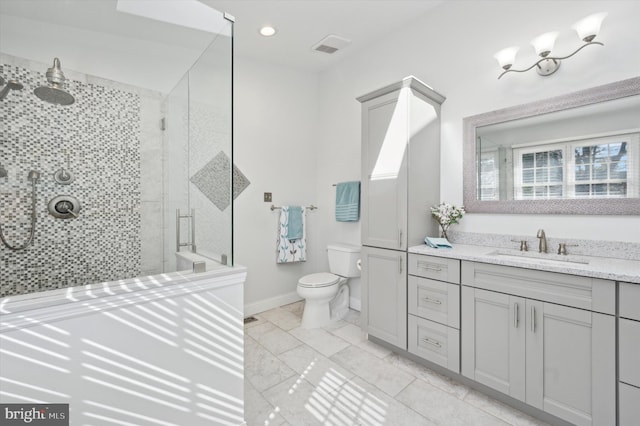 full bathroom with toilet, a stall shower, baseboards, and vanity