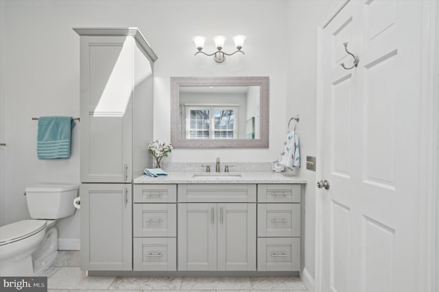 bathroom featuring marble finish floor, vanity, toilet, and baseboards