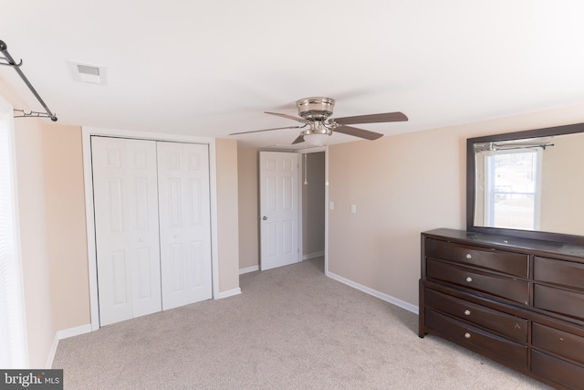 unfurnished bedroom with light colored carpet, ceiling fan, and a closet