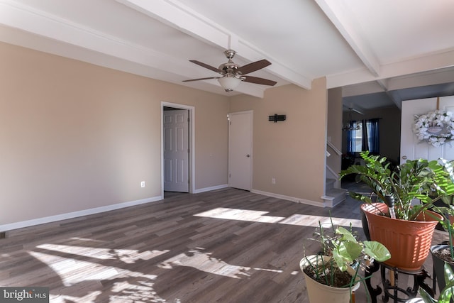 interior space featuring dark hardwood / wood-style flooring, ceiling fan, and beam ceiling