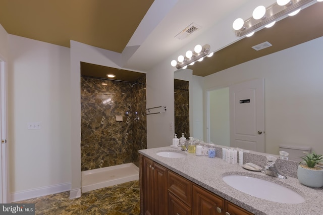 bathroom featuring tiled shower, vanity, and toilet