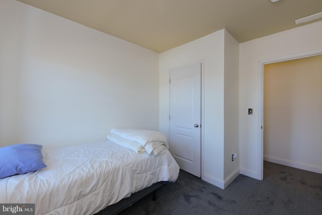 unfurnished bedroom with dark colored carpet