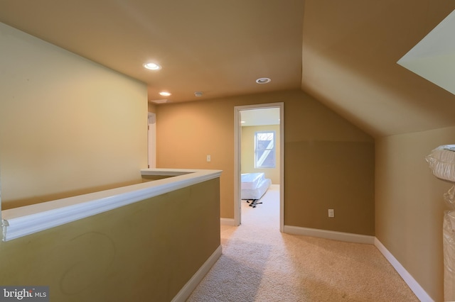 additional living space featuring vaulted ceiling and light colored carpet