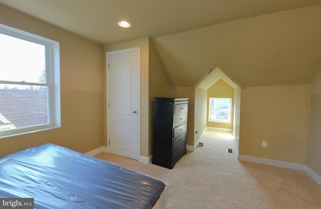 bedroom featuring light carpet and vaulted ceiling