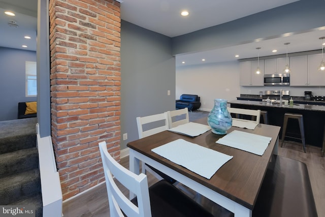 dining space with sink and dark wood-type flooring