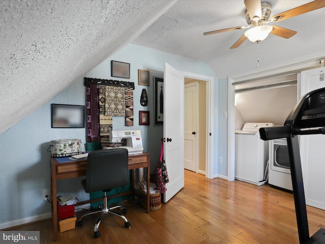 home office featuring lofted ceiling, ceiling fan, light hardwood / wood-style floors, a textured ceiling, and washer / clothes dryer