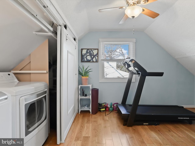 exercise area featuring vaulted ceiling, washer and dryer, ceiling fan, and light wood-type flooring