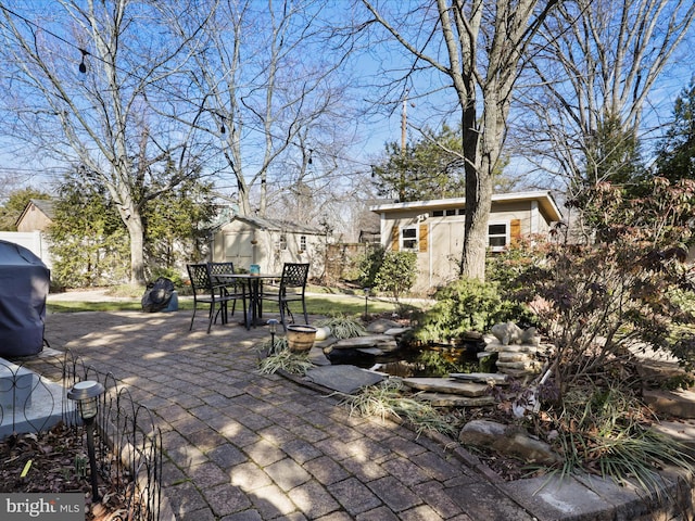 view of patio / terrace with a grill and a storage unit