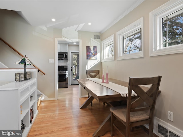 dining area featuring crown molding and light hardwood / wood-style flooring