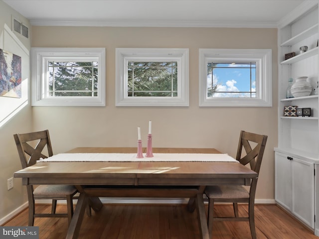 dining room with sink, hardwood / wood-style flooring, and ornamental molding