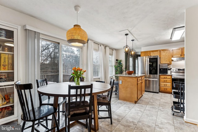 tiled dining space featuring a textured ceiling