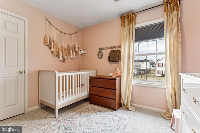 bedroom featuring a crib and light colored carpet