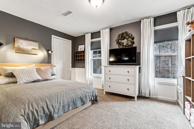 bedroom with carpet floors and a textured ceiling