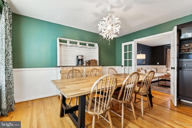 dining space featuring a notable chandelier and light wood-type flooring