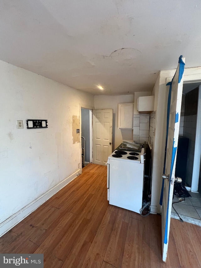 kitchen featuring white cabinetry, hardwood / wood-style floors, and white electric range