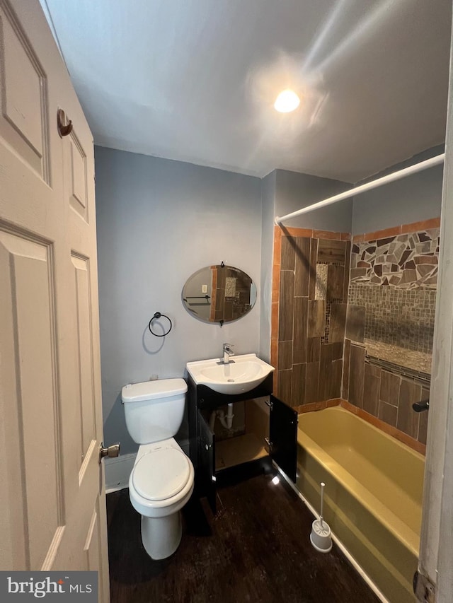 full bathroom with tiled shower / bath, wood-type flooring, vanity, and toilet