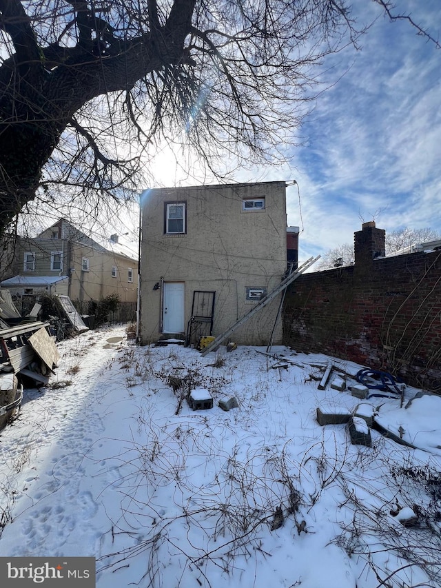 view of snow covered back of property