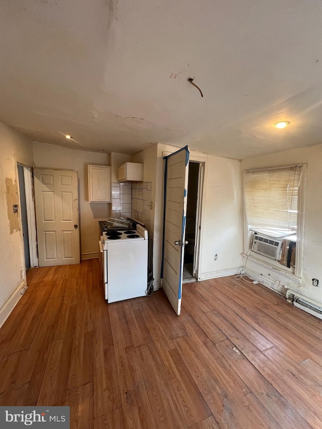 kitchen featuring electric stove, white cabinetry, hardwood / wood-style floors, and cooling unit