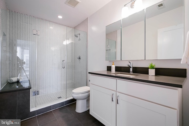 bathroom featuring tile patterned flooring, vanity, toilet, and an enclosed shower