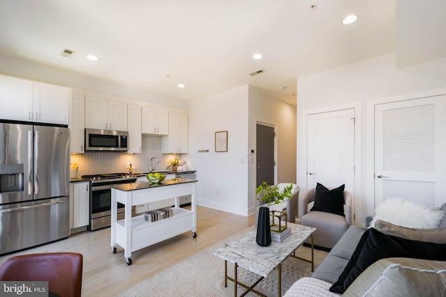 living room featuring sink and light wood-type flooring