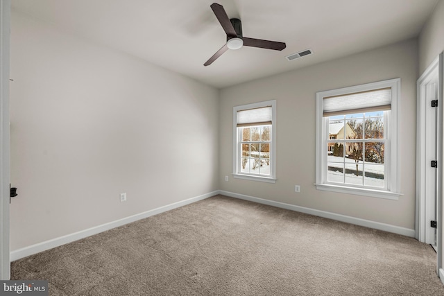 carpeted empty room featuring ceiling fan and a healthy amount of sunlight