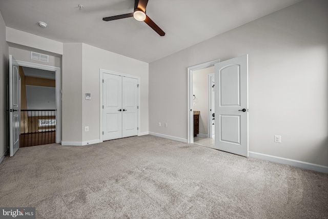 unfurnished bedroom featuring light colored carpet, ceiling fan, and a closet