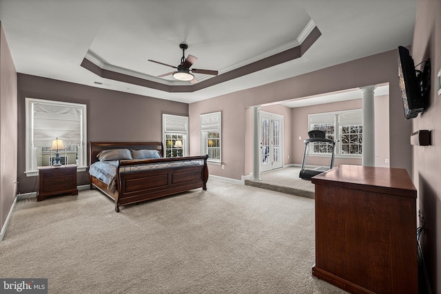 carpeted bedroom featuring crown molding, access to exterior, a raised ceiling, and decorative columns