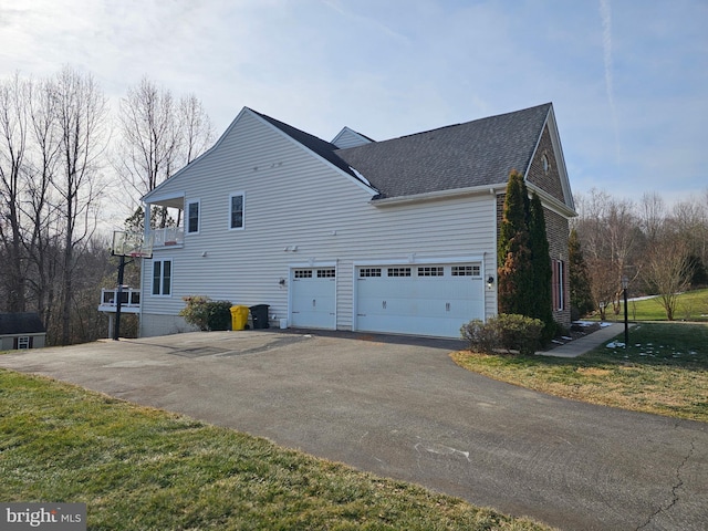 view of side of property featuring a garage and a yard