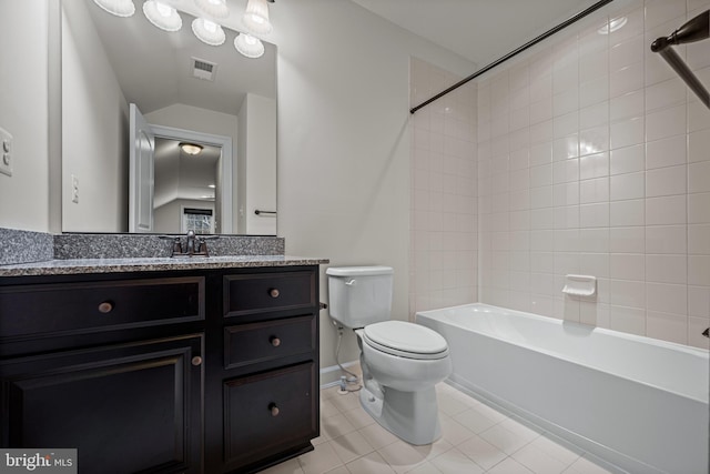 full bathroom featuring tile patterned floors, toilet, vaulted ceiling, vanity, and tiled shower / bath combo