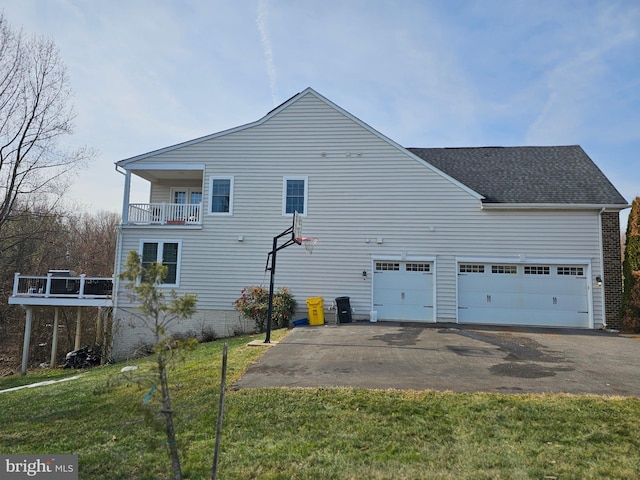 view of property exterior with a balcony, a yard, and a garage