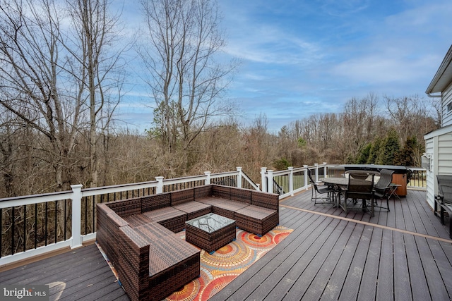 wooden terrace with an outdoor living space with a fire pit