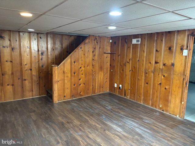 finished basement featuring wood walls, stairs, visible vents, and wood finished floors