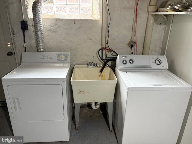 washroom featuring a sink, laundry area, and washer and dryer