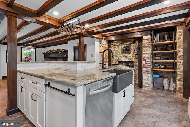 kitchen featuring stainless steel dishwasher, sink, a kitchen island with sink, and white cabinets