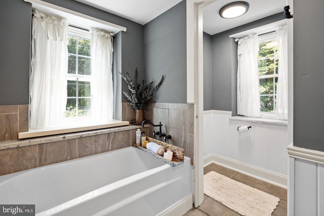 bathroom featuring a tub to relax in and plenty of natural light