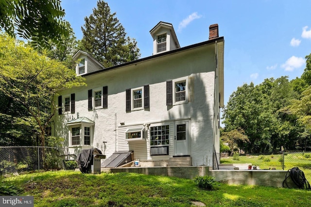 rear view of property with a yard