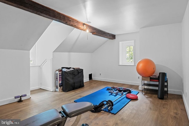 workout area with hardwood / wood-style floors and vaulted ceiling