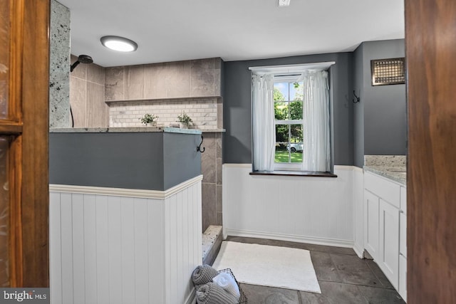 bathroom with backsplash, vanity, and a shower