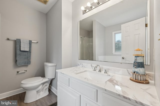 full bath with a shower, toilet, vanity, wood finished floors, and baseboards