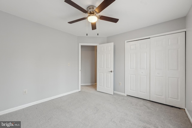 unfurnished bedroom featuring a closet, light colored carpet, ceiling fan, and baseboards